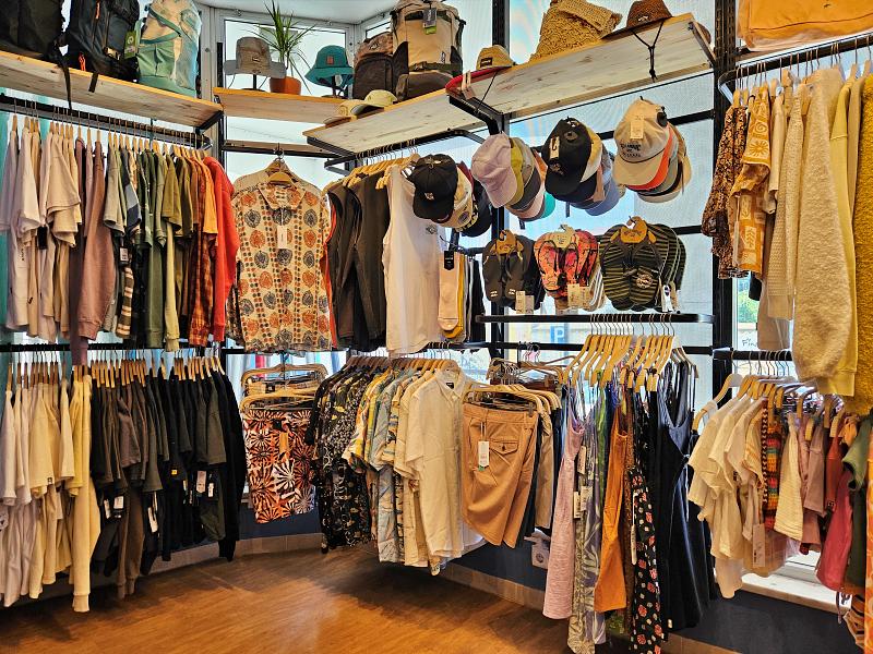 a grove of clothes hanging on a rack in a store