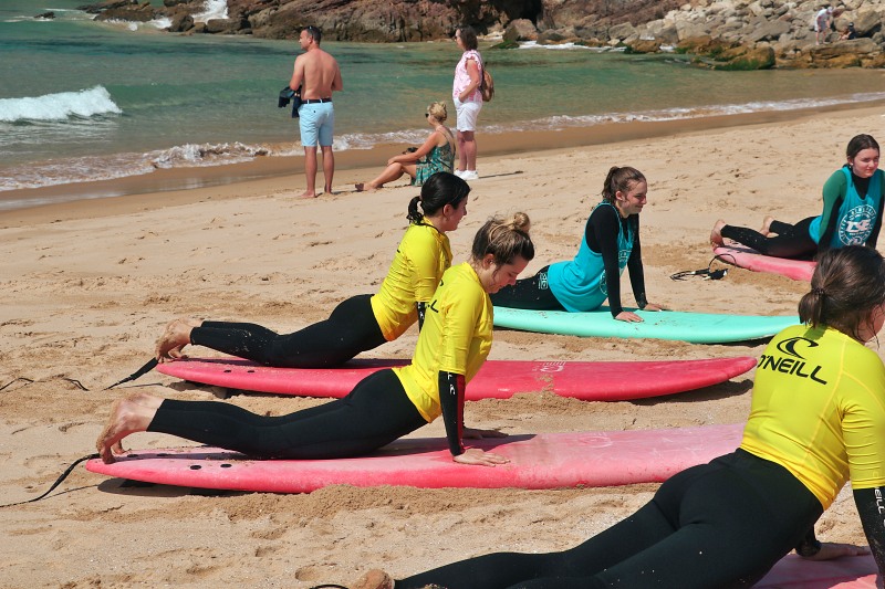 a group of surf lesson warming up for the surf