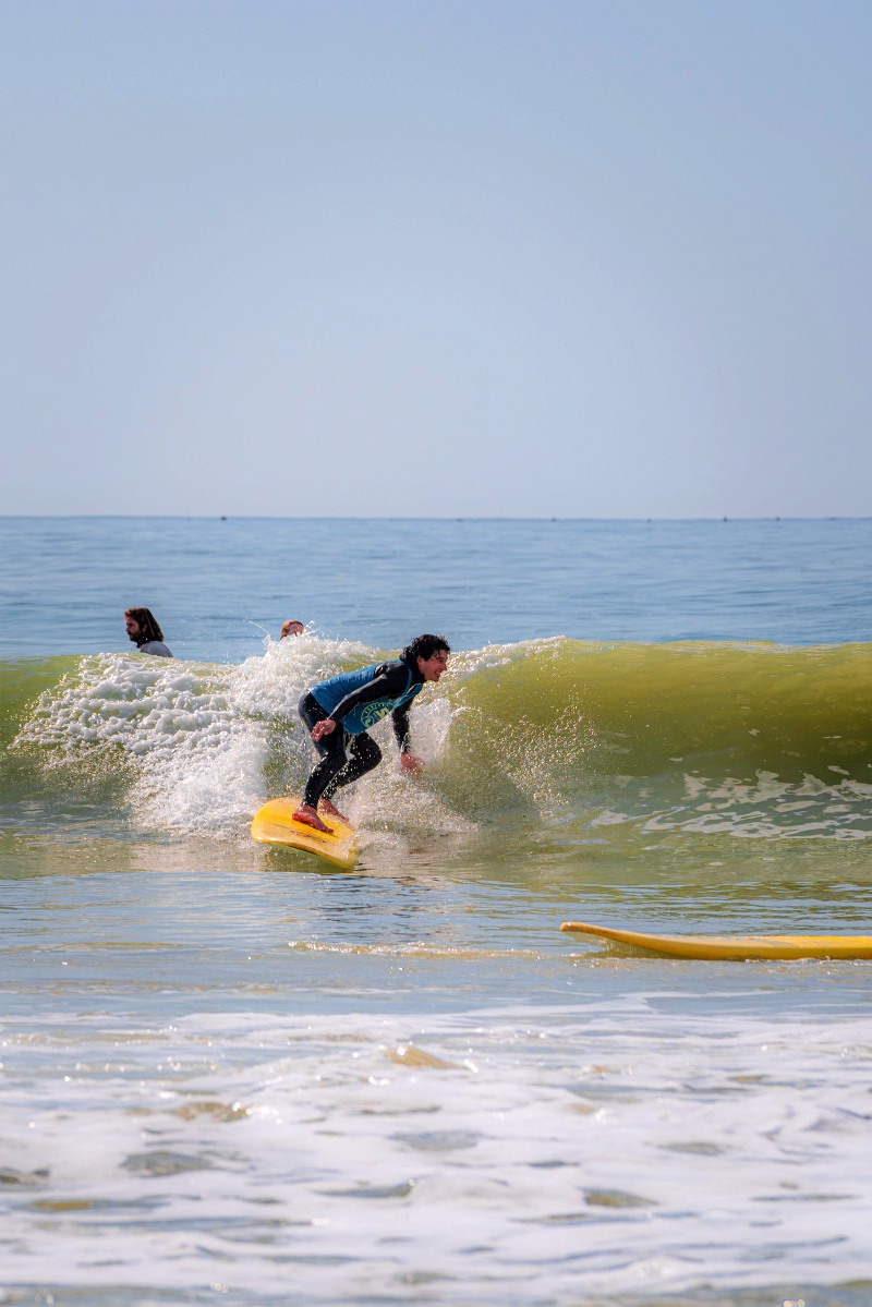 A participant in a surf lesson riding a wave